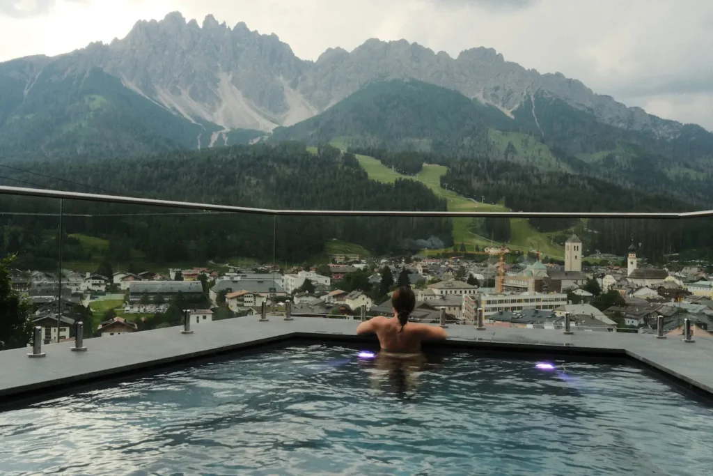 Girl in a pool looking out at mountains