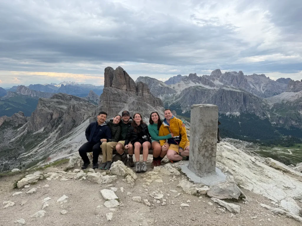 group of people smiling on mountain top