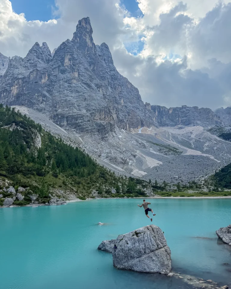 Guy jumping on rock in Dolomites