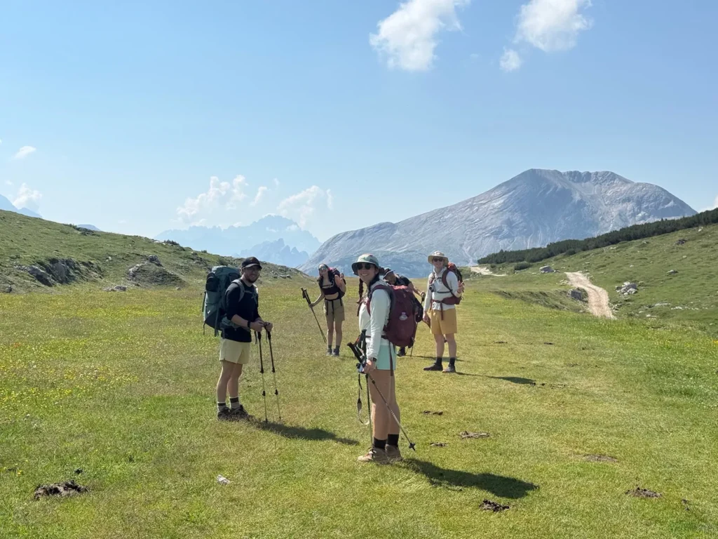 group of people hiking through meadow