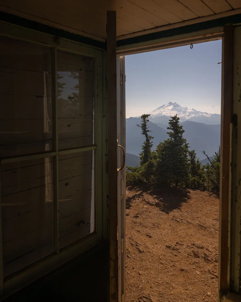 view out of a fire lookout with Mt Baker framed in doorway